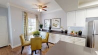 Located on Crape Myrtle Court in Los Angeles, CA, this two-story home offers a thoughtfully designed interior with consistent finishes across all levels. The living room serves as a welcoming centerpiece, featuring crown molding, hardwood-style flooring, large windows with views of surrounding greenery, and a sliding glass door that invites natural light throughout the day. Neutral gray walls complement the bright, airy atmosphere of the space.

The kitchen is well-appointed with white shaker-style cabinetry, gray quartz countertops, a tile backsplash, stainless steel appliances including a refrigerator, range, microwave, and dishwasher, and a skylight that adds additional brightness. An adjoining dining area features a ceiling fan and built-in cabinetry, creating a functional and cohesive space.

The bedrooms offer carpeted flooring and soft, neutral tones. The primary bedroom includes mirrored closet doors and a sliding glass door with outdoor access. Additional bedrooms provide ample space and natural light. Bathrooms are finished with wood-style flooring, white tub-shower combinations with chrome fixtures, and vanities with gray countertops.