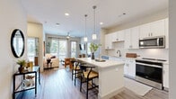 This thoughtfully designed 2-bedroom, 2-bathroom residence in Hendersonville, TN offers a well-appointed single-floor layout that maximizes both comfort and functionality. The open-concept kitchen and living area serves as the heart of the home, featuring crisp white shaker cabinetry, a subway tile backsplash, stainless steel appliances, and a central island with bar seating illuminated by pendant lighting. Wood-style flooring flows throughout the main living areas, complementing the bright, neutral color palette. The living room receives generous natural light through large windows and a glass door that opens to a private balcony, with a ceiling fan adding a practical touch. Both bedrooms are carpeted and well-sized, with large windows that invite abundant daylight and views of the surrounding greenery. The primary bedroom includes a dedicated walk-in closet with wire shelving systems for organized storage. Each bathroom is finished with wood-style flooring and features a tub-shower combination with white tile surround. A second walk-in closet provides additional storage. The overall ambiance is clean, modern, and inviting, offering a comfortable living experience in a well-connected Hendersonville location.