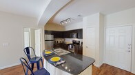 This single-floor residence offers a thoughtfully designed layout that balances functionality and comfort throughout. The kitchen serves as a standout feature, showcasing dark espresso cabinetry, granite countertops, and a full suite of stainless steel appliances including a refrigerator, electric range, and built-in microwave. A peninsula with a double stainless steel sink provides additional prep space and casual seating, while a subway tile backsplash and track lighting add a modern touch. The kitchen flows naturally into the main living area, which is finished with warm hardwood-style flooring, a ceiling fan, and a glass door that invites natural light and outdoor access.

The bedrooms are carpeted and generously sized, each featuring a ceiling fan with light, neutral-toned walls, and windows with blinds that allow for natural light while maintaining privacy. The rooms offer a calm and restful ambiance well-suited for relaxation.

The bathroom is finished with light tile flooring, a vanity with dark countertops, a linen closet, and a tub/shower combination with decorative tile accents. A walk-in closet is accessible from the kitchen area, adding practical storage. Overall, the space presents a clean, modern aesthetic with consistent finishes throughout.
