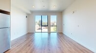 Located at 532 Union Street in Oakland, CA, this 440-square-foot studio unit offers a thoughtfully designed single-floor layout comprising an open-plan kitchen and living area along with one full bathroom. The kitchen is outfitted with modern stainless steel appliances, including a gas range, over-the-range microwave, dishwasher, and refrigerator. Light wood-tone cabinetry extends from floor to ceiling, providing ample storage, while white countertops and a stainless steel sink complete the clean, contemporary aesthetic. Warm hardwood-style flooring runs throughout the unit, lending continuity and a welcoming feel to the open living space. The living area is highlighted by two large floor-to-ceiling windows framed in sleek black, filling the room with abundant natural light and offering open views of the surrounding Oakland neighborhood and tree line. Recessed lighting supplements the natural light throughout. The bathroom features a full tub/shower combination with subway tile surround, neutral tile flooring, and chrome grab bars, reflecting a clean and accessible design. The unit's open, minimalist layout and modern finishes make it a functional and well-appointed living space in the heart of Oakland.
