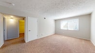 Located at 1909 Tracy Dr in Bloomington, Illinois, this single-floor home offers a clean, functional layout with a variety of updated finishes throughout. The kitchen is a standout feature, showcasing crisp white shaker-style cabinetry, granite-look countertops, and black appliances including an electric range, over-the-range hood, and dishwasher. Wood-look plank flooring runs through the kitchen, adding warmth and durability to the space.

The bedrooms are generously sized, each finished with plush wall-to-wall carpeting and neutral-toned walls that create a calm, comfortable atmosphere. Multiple bedrooms feature windows with blinds that allow natural light to filter in, and several include closets with built-in storage. Ceiling fans are present in select rooms, providing added comfort. Textured ceilings are consistent throughout the carpeted areas of the home.

The bathroom continues the home's updated aesthetic with wood-look flooring, a granite-look vanity countertop, a tub-shower combination, and a clean white finish throughout. The overall layout, as seen in the dollhouse view, reflects a well-organized single-level floor plan with clear room separation, making this home both practical and comfortable for everyday living.