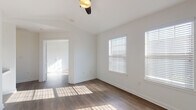 Located at 2710 Cunningham Rd in Killeen, Texas, this single-story home offers a clean, modern interior with a cohesive design aesthetic throughout. The living spaces are finished with rich wood-look flooring that runs continuously across the rooms, complemented by crisp white walls and white baseboards that create a bright, welcoming atmosphere.

The bedrooms are well-proportioned, each featuring ceiling fans for year-round comfort and multiple windows dressed with white blinds that allow generous natural light to fill the rooms. Crown molding accents the ceilings in select rooms, adding a refined architectural touch.

The kitchen is thoughtfully appointed with white shaker-style cabinetry, granite-look countertops, and black appliances including a refrigerator, electric range, and over-the-range microwave. A door with a window leads directly outside, providing convenient access and additional natural light to the cooking space. Ample upper and lower cabinet storage ensures functional use of the space.

The bathroom maintains the home's clean design language, featuring white cabinetry with brushed nickel hardware, wood-look flooring, and neutral white walls. The layout is efficient and well-organized, with a towel bar and toilet paper holder in brushed nickel finishes.

Overall, this home presents a move-in ready interior with consistent finishes, abundant natural light, and practical layouts suited for comfortable everyday living.