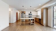 Located at 7570 32nd St N in Oakdale, Minnesota, this thoughtfully designed 4-bedroom, 2-bathroom home offers a clean, modern aesthetic throughout its single-floor layout. The open-concept kitchen serves as the heart of the home, showcasing a striking two-tone cabinetry design with warm wood lower cabinets and crisp white upper cabinets. Stainless steel appliances, a white tile backsplash, white quartz countertops, and a freestanding island with pendant lighting above complete the space with both style and function. Warm hardwood-style flooring flows through the main living areas, lending a cohesive and inviting feel. A hallway with doors on either side provides convenient access to multiple rooms. The spacious primary bedroom features sliding glass doors opening to a private balcony with outdoor views. Additional bedrooms are carpeted and bright, with large windows that bring in natural light and neighborhood views. The walk-in closet includes wrap-around wire shelving for ample organization. The bathroom offers a floating double-vanity with warm wood cabinetry, a large mirror, brushed nickel fixtures, and a full soaking tub. Recessed lighting throughout and a neutral color palette create a bright, move-in ready atmosphere across the entire home.