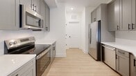 Located at 3311 Hood Ave in Chamblee, GA, this thoughtfully designed 2-bedroom, 2-bathroom single-story home offers a clean, modern aesthetic with high-quality finishes throughout. The open-concept layout seamlessly connects the living room, dining area, and kitchen, creating an inviting and functional common space. Light hardwood-style flooring runs through the main areas, adding warmth and continuity.

The kitchen is a standout feature, equipped with stainless steel GE appliances including a range, over-the-range microwave, refrigerator, and dishwasher. Gray shaker-style cabinetry with matte black hardware pairs elegantly with white quartz countertops and a subway tile backsplash, delivering a polished, contemporary look.

Both bedrooms are carpeted and bathed in natural light from large windows with blinds, and each is outfitted with a ceiling fan. The spacious primary bedroom includes generous closet space with wire shelving systems. Three closets in total provide ample storage throughout the home.

The two bathrooms continue the modern theme, featuring gray shaker vanities with white countertops and backlit mirrors. One bathroom includes a walk-in glass shower with white subway tile surround and chrome fixtures. A dedicated laundry area adds everyday convenience, rounding out this well-appointed home.
