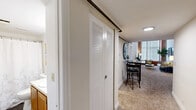 Located at 91 Elm St in Manchester, CT, this two-story, one-bedroom, one-bathroom unit blends industrial character with comfortable living across two well-proportioned floors. The main level hosts the primary living areas, including two living room spaces, a kitchen, and a bathroom, while the upper level accommodates the bedroom. Soaring ceilings and dramatic floor-to-ceiling arched windows framed by exposed brick walls define the living room, flooding the space with natural light and lending a striking loft-like aesthetic. Carpeted floors add warmth throughout the living areas. The kitchen features warm wood cabinetry, ample counter space on both sides, a stainless steel sink, and easy-care wood-look flooring, providing a functional and efficient layout. The bedroom is a serene retreat with its own soaring ceilings, an exposed brick arched window, a built-in closet, and soft carpeting. The bathroom is well-appointed with a tub/shower combination, wood-look flooring, and a vanity with sink. A staircase connects the two floors, as seen in the architectural overview, reinforcing the unit's distinctive two-level design. The combination of industrial elements and modern finishes gives this space a unique, characterful ambiance.