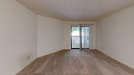 This single-story, 2-bedroom, 2-bathroom home in Greensboro, NC offers a functional and comfortable layout across a well-utilized floor plan. The combined kitchen and living area serves as the central hub of the home. The kitchen is equipped with a black refrigerator and features wood-look flooring, white cabinetry, and a built-in pantry closet with wire shelving for added storage convenience. The living room is carpeted and features a sliding glass door with vertical blinds that opens to a balcony, allowing natural light to fill the space and providing pleasant outdoor views. Both bedrooms are carpeted and feature textured ceilings, neutral wall tones, and windows that bring in natural light. The primary bedroom is a well-proportioned room with direct hallway access. The second bedroom also features a window overlooking the exterior. The two bathrooms offer practical fixtures, including one bathroom with a walk-in shower stall and another with a full shower-tub combination. The home's layout, as seen in the dollhouse overview, shows a clear and efficient floor plan with well-defined spaces throughout. The neutral color palette and consistent flooring materials create a cohesive and clean aesthetic across all rooms.