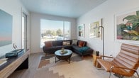 This single-story residence is thoughtfully designed with a contemporary aesthetic, combining functional layouts with modern finishes. The kitchen serves as a central highlight, featuring a galley-style configuration with dark wood lower cabinetry contrasted by crisp white upper cabinets and dark countertops. Stainless steel appliances, including a full-size refrigerator, dishwasher, and over-range microwave, complete the well-equipped space. Light wood-style flooring runs throughout the kitchen and connects seamlessly to the main living areas.

The living room is bright and inviting, benefiting from large windows fitted with horizontal blinds that allow ample natural light while providing outdoor views. Neutral wall tones create a versatile backdrop throughout the space.

Two bedrooms offer comfortable retreats, each featuring plush carpeting, generous windows with curtain panels, and sufficient space for full bedroom furnishings. Both rooms maintain the residence's clean, modern character.

Two bathrooms mirror the kitchen's design language, showcasing dark wood vanities with dark countertops, undermount sinks, wood-style flooring, and tub-shower combinations. The overall ambiance throughout is clean, contemporary, and well-coordinated.