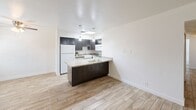 Located in Phoenix, AZ, this single-story home offers three bedrooms and one bathroom across a thoughtfully arranged floor plan. Wood-look tile flooring runs consistently throughout the space, lending a warm, cohesive aesthetic to every room.

The kitchen is a standout feature, equipped with dark espresso cabinetry, granite countertops, white appliances, and a peninsula with pendant lighting overhead. A skylight adds natural brightness to the cooking area, while the open layout connects seamlessly to the adjacent living and dining spaces.

The bedrooms are bright and cleanly finished, featuring crisp white walls and sliding closet doors for convenient storage. Multiple windows dressed with blinds and vertical window treatments allow natural light to filter in throughout the day. One bedroom features painted brick-style walls, adding subtle textural character to the space.

The bathroom is clean and functional, featuring a full tub and shower combination with built-in corner shelving, a small window for ventilation and natural light, and white tile surround.

A hallway connects the private bedroom wing to the main living areas, creating a practical layout. Overall, the home presents a clean, updated aesthetic with neutral tones and modern finishes, making it a well-appointed residence in the Phoenix area.