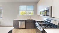 Located at 202 Park Blvd in Cherry Hill, NJ, this well-appointed two-bedroom, two-bathroom residence offers a thoughtfully designed single-floor layout with a clean, contemporary aesthetic throughout. The interior is finished with light hardwood-style flooring that flows seamlessly across the living areas and bedrooms, complemented by neutral gray walls and crisp white trim that create a bright, modern atmosphere.

The open-concept kitchen is a standout feature, showcasing two-tone cabinetry with dark lower cabinets and white uppers, white quartz countertops, a classic subway tile backsplash, and stainless steel appliances including a gas range, dishwasher, and refrigerator. A kitchen island provides additional workspace, while a large window frames views of the surrounding greenery and fills the space with natural light. Pendant lighting adds a finishing touch.

Both bedrooms are generously proportioned, each featuring wide windows that invite ample sunlight and outdoor views. The spacious primary bedroom offers a comfortable retreat. The two bathrooms are finished with light tile flooring, dark wood vanities, white countertops, and mirrored medicine cabinets. Additional conveniences include four closets, a dedicated laundry area, and a private patio, rounding out this well-equipped residence.