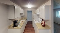 This single-floor space offers a well-organized layout with a functional and efficient design. The galley-style kitchen is a standout feature, lined on both sides with white cabinetry that provides generous storage space. Light countertops run the length of both walls, complemented by a full suite of white appliances including a range and refrigerator. Wood-look flooring runs underfoot, and a textured ceiling adds classic character to the space.

The living area is open and versatile, featuring a combination of wood-look flooring that transitions seamlessly into plush carpeting, creating a warm and inviting atmosphere. Neutral-toned walls throughout the unit provide a clean, adaptable backdrop. The textured ceilings are consistent across all rooms, lending a cohesive aesthetic to the interior.

The bedrooms are carpeted and well-proportioned, offering a comfortable and quiet retreat. Each room benefits from neutral wall tones and clean white baseboards, keeping the spaces feeling bright and move-in ready.

The bathroom features a vanity with a white sink, light countertop, and under-sink cabinetry for storage. A medicine cabinet with a mirror sits above the vanity, and a sliding door leads to the shower. Wood-look flooring extends into this space, tying the overall design together. The layout is practical and efficiently designed throughout.