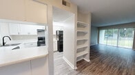 Located at 1327 High Rd in Tallahassee, Florida, this single-floor unit features a clean, updated interior with a neutral color palette and consistent hard-surface flooring throughout the main living areas. The open-concept layout connects the living room, dining area, and kitchen seamlessly. The living room is bright and spacious, anchored by a large sliding glass door with vertical blinds that invite abundant natural light and offer views of the surrounding greenery.

The kitchen is well-equipped with white cabinetry, light stone countertops, black appliances including a range and refrigerator, and a deep basin sink. A peninsula-style counter provides additional prep space and serves as a natural divider between the kitchen and adjoining areas. A built-in open shelving unit adds functional display and storage space between the kitchen and living room.

The bathroom features a white vanity with stone countertops, a black matte faucet, and stylish industrial-style lighting, alongside a full tub-shower combination. The bedroom includes dual closets with sliding doors and plush carpet underfoot. A hallway with wood-look flooring, textured ceilings, and a wall-mounted thermostat connects the rooms efficiently, completing this well-maintained and thoughtfully updated single-floor residence.