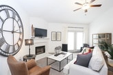 This thoughtfully designed single-floor residence offers a seamless blend of modern style and everyday comfort across a well-organized layout. The kitchen is a standout feature, showcasing rich dark cabinetry, granite countertops, a classic subway tile backsplash, stainless steel appliances, and light hardwood-style flooring — all complemented by pendant lighting that adds a warm, inviting glow. A peninsula counter provides additional workspace and casual seating.

The living room is a welcoming retreat centered around a white-mantled fireplace, with plush carpeting, vaulted-style ceilings, a ceiling fan, and French doors that invite natural light into the space. The bedrooms continue the comfortable aesthetic with soft carpeting, ceiling fans, and tasteful natural light from windowed walls dressed in classic curtains.

The primary bathroom is well-appointed with dark wood cabinetry, a white countertop vanity, hardwood-style flooring, and a tiled walk-in shower. A secondary bathroom features a soaking tub framed by elegant large-format tile surround. The dedicated laundry room includes full-size washer and dryer units, open shelving, and additional cabinetry with granite countertop, making it as functional as it is refined throughout.