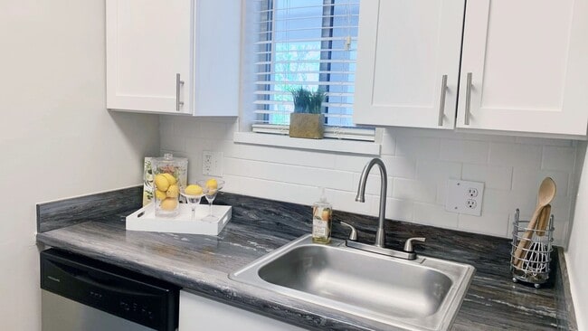 Enjoy an elegant studio kitchen with stainless-steel appliances, including a dishwasher, for inspired living with convenience and charm. - Lakewood Village