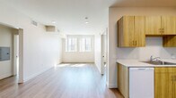 Located at 6940 Owensmouth Ave in the Canoga Park neighborhood of Los Angeles, this 2-bedroom, 1-bathroom unit delivers a clean, contemporary design across a single, well-organized floor. Light-toned wood-style flooring runs throughout, creating a cohesive and airy aesthetic that connects every room seamlessly.

The open living area benefits from multiple windows that invite generous natural light, keeping the space feeling bright and welcoming. The galley-style kitchen is thoughtfully appointed with warm wood-grain cabinetry spanning both walls, white countertops, a stainless sink, and white appliances including a range and full-size refrigerator — providing ample storage and a practical cooking environment.

Both bedrooms feature neutral walls, wood-style flooring, and windows that bring in natural light. The primary bedroom includes a sliding-door closet for efficient storage, while a second closet is also available within the unit. The full bathroom is finished with a wood-tone vanity, white countertop, a large mirror with overhead lighting, and a bathtub with tile surround. The overall design palette of whites, creams, and warm wood tones gives the unit a fresh, modern character well-suited for comfortable everyday living.