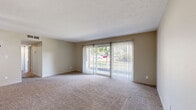 Located at 6500 Maplewood Rd in Mayfield Heights, Ohio, this two-bedroom, one-bathroom residence offers a practical and comfortable single-floor layout. The living room is a generous, open space finished with plush carpeting and anchored by large sliding glass doors dressed with vertical blinds, allowing ample natural light and providing outdoor views of the surrounding greenery. The kitchen is well-equipped with taupe cabinetry, a gas range, dishwasher, full-size refrigerator, and a double sink, all set atop durable hardwood-style flooring. Both bedrooms feature soft carpeting, neutral warm-toned walls, and natural light from windows with blinds. The primary bedroom is notably spacious and includes two closets with bifold doors, offering generous storage. The second bedroom also includes a closet and a window with outdoor views. A hallway connects the main living areas to the bedrooms and full bathroom, which features a clean, tiled tub-shower combination in white. Throughout the residence, neutral beige tones and clean finishes create a cohesive, understated ambiance suited for comfortable everyday living.