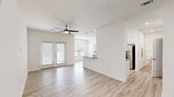 Located at 10293 Cassle Rd in Denham Springs, Louisiana, this single-story home offers a thoughtfully designed open-concept layout across a comfortable floor plan. Light wood-style flooring runs continuously throughout, complementing the crisp white walls and bright, airy atmosphere found in every room.

The kitchen is a standout feature, showcasing white shaker cabinetry, granite countertops, a subway tile backsplash, and a full suite of stainless steel appliances. A peninsula with pendant lighting provides additional counter space and connects seamlessly to the living area, where a ceiling fan and French doors invite natural light and outdoor access.

The bedroom is generously sized with a ceiling fan, a large window with outdoor views, and direct access to a dedicated closet. The bathroom is well-appointed with white cabinetry, granite countertops, a full soaking tub with a shower curtain rod, and matching wood-style flooring that ties the space together cohesively.

A hallway connects the main living areas to the private quarters, contributing to a logical and functional flow throughout the home. Clean lines, neutral tones, and modern fixtures define the overall aesthetic, making this a move-in ready home with contemporary appeal.