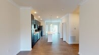 Located at 300 Old Mill Rd in Oakdale, PA, this two-floor residence offers a well-appointed layout with thoughtful finishes throughout. The kitchen is a standout feature, showcasing dark espresso cabinetry, white countertops, a classic subway tile backsplash, and a full suite of stainless steel appliances including a refrigerator, range, microwave, and dishwasher. A central island with pendant lighting connects the kitchen to the open dining and living area, which is finished with rich hardwood-style flooring and crown molding. A large sliding glass door in the living area invites ample natural light and provides outdoor views. A convenient half bath is accessible on the main level. The upper floor features generously sized bedrooms with plush carpeting, ceiling fans, and large windows that frame views of the surrounding greenery. The bathrooms are finished with dark vanity cabinetry, white countertops, brushed nickel fixtures, and a distinctive black-and-white hexagonal tile floor in one bath. Throughout the space, a neutral color palette, recessed lighting, and clean architectural lines create a bright, modern, and cohesive ambiance.