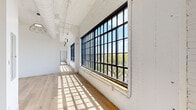 Located at 2528 Texas Ave in St. Louis's vibrant 63104 corridor, this single-floor industrial loft masterfully balances historic character with contemporary design. Original white-painted brick walls and exposed ductwork pay homage to the building's industrial roots, while light hardwood flooring and soaring ceilings create an open, airy atmosphere throughout.

Expansive steel-framed grid windows line the main living area, flooding the space with abundant natural light and offering elevated views of the surrounding St. Louis skyline and treetops. The open-concept kitchen is a standout, featuring dark cabinetry, stainless steel appliances, a large island with dark stone countertops, a brass gooseneck faucet, and subway tile backsplash — all illuminated by a striking globe pendant light. An in-unit stacked washer and dryer are conveniently tucked nearby.

The bedrooms are generously proportioned, with white walls, hardwood floors, and access to natural light. The bathroom showcases a clean, modern aesthetic with white grid-patterned tile, matte black fixtures, a soaking tub, and a floating wood vanity with a backlit mirror. Distinctive pendant lighting and geometric fixtures add an artistic touch throughout, completing this refined yet industrial-inspired urban retreat.