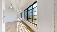 Located at 2528 Texas Ave in St. Louis's vibrant 63104 corridor, this single-floor industrial loft masterfully balances historic character with contemporary design. Original white-painted brick walls and exposed ductwork pay homage to the building's industrial roots, while light hardwood flooring and soaring ceilings create an open, airy atmosphere throughout.

Expansive steel-framed grid windows line the main living area, flooding the space with abundant natural light and offering elevated views of the surrounding St. Louis skyline and treetops. The open-concept kitchen is a standout, featuring dark cabinetry, stainless steel appliances, a large island with dark stone countertops, a brass gooseneck faucet, and subway tile backsplash — all illuminated by a striking globe pendant light. An in-unit stacked washer and dryer are conveniently tucked nearby.

The bedrooms are generously proportioned, with white walls, hardwood floors, and access to natural light. The bathroom showcases a clean, modern aesthetic with white grid-patterned tile, matte black fixtures, a soaking tub, and a floating wood vanity with a backlit mirror. Distinctive pendant lighting and geometric fixtures add an artistic touch throughout, completing this refined yet industrial-inspired urban retreat.