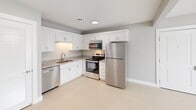 Located at 4949 Garfield Rd in Auburn, MI, this 2-bedroom, 1-bathroom single-floor unit offers a clean, contemporary design throughout. The open-concept main living area combines the dining room, kitchen, and living room into one cohesive space, finished with light hardwood-style flooring and neutral gray walls that create a bright, airy atmosphere. The kitchen is well-appointed with white shaker-style cabinetry, granite countertops, a stainless steel refrigerator, range, over-the-range microwave, and dishwasher, alongside a dedicated pantry for additional storage. Both bedrooms feature plush carpeting, large windows that bring in natural light and views of the surrounding area, and closet space. The primary bedroom is a comfortable size and includes its own closet. The bathroom is equipped with a full tub-and-shower combination with chrome fixtures. Additional conveniences include an in-unit laundry area and a balcony. The unit's consistent use of soft neutral tones, white trim, and modern finishes throughout gives the space a cohesive and move-in-ready feel.