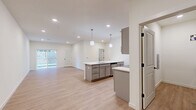 Located at 15 Ore Bank Rd in Dillsburg, PA, this well-designed one-bedroom, one-bathroom unit offers a thoughtfully organized single-floor layout. The open-concept kitchen and living area serves as the heart of the home, featuring a central island with crisp white quartz countertops, a stainless steel sink, and sleek gray shaker-style cabinetry. Stainless steel appliances—including a refrigerator, range, and over-the-range microwave—complement the modern aesthetic. Pendant lighting above the island adds a polished touch, while light wood-look flooring and recessed lighting create a bright, welcoming ambiance throughout. A sliding glass door in the living area allows natural light to fill the space and provides access to the outdoors. The bedroom is a comfortable, private retreat finished with plush carpeting and a window that brings in natural light. A louvered closet door adds a classic detail to the room. The full bathroom includes a tub-shower combo with clean white surrounds. A dedicated laundry area houses a full-size top-load washer and dryer, adding everyday convenience. Clean white walls, modern black hardware accents, and consistent finishes throughout give this unit a cohesive and contemporary feel.