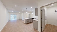 Located at 15 Ore Bank Rd in Dillsburg, PA, this well-designed one-bedroom, one-bathroom unit offers a thoughtfully organized single-floor layout. The open-concept kitchen and living area serves as the heart of the home, featuring a central island with crisp white quartz countertops, a stainless steel sink, and sleek gray shaker-style cabinetry. Stainless steel appliances—including a refrigerator, range, and over-the-range microwave—complement the modern aesthetic. Pendant lighting above the island adds a polished touch, while light wood-look flooring and recessed lighting create a bright, welcoming ambiance throughout. A sliding glass door in the living area allows natural light to fill the space and provides access to the outdoors. The bedroom is a comfortable, private retreat finished with plush carpeting and a window that brings in natural light. A louvered closet door adds a classic detail to the room. The full bathroom includes a tub-shower combo with clean white surrounds. A dedicated laundry area houses a full-size top-load washer and dryer, adding everyday convenience. Clean white walls, modern black hardware accents, and consistent finishes throughout give this unit a cohesive and contemporary feel.