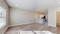 Located at 870 Needmore Rd in Clarksville, TN, this two-story home offers four bedrooms, three bathrooms, and a thoughtfully designed layout spread across two well-proportioned floors. The main level features an open-concept kitchen and living area, where light vinyl plank flooring, recessed lighting, and large windows combine to create a bright and welcoming atmosphere. The kitchen is outfitted with white shaker-style cabinetry, black hardware accents, light countertops, a dual-basin sink with a matte black faucet, and a full suite of stainless steel appliances including a refrigerator, range, microwave, and dishwasher. A peninsula with pendant lighting visually connects the kitchen to the living area. Bedrooms are found on both floors, with several rooms featuring vinyl plank flooring and large windows that invite natural light, while at least one bedroom is finished with neutral carpet. Ceiling fans are present in select bedrooms. The three bathrooms are finished consistently with white vanities, black hardware, light countertops, and tub-shower combos with built-in shelving. A utility room and two closets add practical storage. The overall aesthetic is clean, modern, and move-in ready.