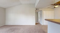 Located at 5575 Rosebriar Way in Orlando, FL, this one-bedroom, one-bathroom unit offers a well-organized layout across a single floor. The combined living and dining area is a standout, featuring vaulted ceilings with exposed beam detailing, a textured ceiling, and soft carpeting throughout. A tile-surround wood-burning fireplace with a white mantel serves as the focal point of the living room, flanked by windows that allow natural light to filter in. A ceiling fan overhead adds both function and comfort to the space.

The galley-style kitchen is efficiently designed with light wood-tone flooring, ample cabinetry on both sides, a full suite of black appliances including a range and refrigerator, a double sink, and a dedicated closet for additional storage. A breakfast bar connects the kitchen to the living area, enhancing the open feel.

The bedroom is a comfortable, carpeted retreat with a textured ceiling, a door leading to a private outdoor area, and access to a dedicated closet. The bathroom features a clean, white-tiled tub-shower combination with updated fixtures. A hallway connects the main living spaces, completing this practical and cozy floor plan.