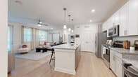 Located in Spring Hill, Tennessee, this well-appointed single-story residence offers two bedrooms, two bathrooms, a dedicated office, and a thoughtfully designed open-concept layout. The kitchen is a standout feature, showcasing white shaker cabinetry, granite countertops, stainless steel appliances, and a large center island with bar seating illuminated by pendant lighting — flowing seamlessly into the living area, which is brightened by multiple windows with natural light. Light-toned wood-look flooring runs throughout, creating a cohesive and clean aesthetic. The primary bedroom is generously sized, featuring a ceiling fan, large window, and walk-in closet with built-in wire shelving. The second bedroom is equally bright and comfortable, with a large window and ample space. Both bathrooms are finished with granite vanity tops and tile-surround tub/shower combinations. The dedicated office provides a quiet, functional workspace. Two closets offer practical storage solutions throughout the home. The overall ambiance is modern, bright, and welcoming — ideal for those seeking a well-organized, move-in ready home in the Spring Hill community.