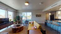 Located at 605 George Washington Way in Richland, Washington, this single-floor unit offers a well-designed, contemporary layout with a cohesive blend of modern finishes and functional living spaces. Wood-look plank flooring runs throughout the main areas, providing a warm, consistent foundation that ties the open floor plan together.

The kitchen serves as a focal point, featuring white upper cabinetry, dark lower cabinetry, dark countertops, and stainless steel appliances including a microwave and range. A central island with seating for two is illuminated by pendant lighting, making it ideal for casual dining or entertaining. The kitchen flows directly into the living area, which benefits from a sliding glass door that draws in natural light and provides outdoor access.

The living room offers generous space with neutral walls and additional windows that brighten the interior. A dedicated hallway connects the main living areas to the bedrooms, each of which features plush carpeting and large windows with outdoor views. The bathroom is cleanly finished with neutral tones and wood-look flooring. A dedicated in-unit laundry area houses a front-load washer with overhead shelving, adding practical convenience. The overall ambiance is modern, clean, and well-lit throughout.