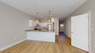 Located in Sellersburg, Indiana, this well-designed two-story home offers a thoughtful layout across two levels with modern finishes throughout. The open-concept main level centers around a stylish kitchen equipped with crisp white cabinetry, granite countertops, a peninsula island with a sink, pendant lighting, and stainless steel appliances including a refrigerator, range, and microwave. Warm hardwood-style flooring extends through the main living areas, enhancing the bright and welcoming ambiance. A dedicated pantry with wire shelving provides ample storage adjacent to the kitchen. The upper level features carpeted bedrooms, including a spacious walk-in closet outfitted with wire shelving and hanging rods. Large windows fitted with blinds allow natural light to fill the bedrooms. The bathrooms are finished with granite-topped vanities and hardwood-style flooring; the primary bathroom includes a dual-sink vanity with rich wood cabinetry and a walk-in shower, while a secondary bathroom offers a clean, functional shower unit with built-in shelving. A dedicated laundry area houses full-size top-loading GE washer and dryer units with overhead wire shelving for added convenience. Throughout the home, neutral tones and quality finishes create a clean, move-in ready atmosphere.