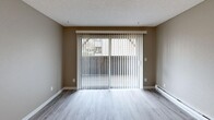 Located at 4922 123rd St SW in Lakewood, Washington, this two-bedroom, one-bathroom unit offers a well-organized single-floor layout. The living room is a welcoming space highlighted by wood-look LVP flooring, neutral gray walls, a textured ceiling, and a full-width sliding glass door fitted with vertical blinds that opens to an outdoor balcony, filling the room with natural light and outdoor views. Baseboard heating runs along the walls for consistent comfort throughout the unit. The kitchen is efficiently designed with white cabinetry, light countertops, and stainless steel appliances, including a range and microwave, all set on light LVP flooring. Both bedrooms feature plush carpeting and neutral tones, with the primary bedroom offering a generous closet. A well-appointed walk-in closet with built-in shelving and hanging rods provides ample storage. The bathroom includes a full tub and shower combination with chrome fixtures. A hallway connects all rooms, and additional closets throughout the unit offer practical storage solutions. The overall aesthetic is clean, neutral, and move-in ready.