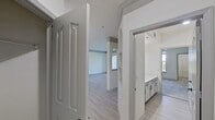 This contemporary residence boasts an open floor plan that seamlessly integrates the living and dining areas with the kitchen. The living space is illuminated by large windows and a modern ceiling fan, while the kitchen features white cabinetry, stainless steel appliances, and a subway tile backsplash. A separate laundry room offers convenience with ample storage. Bedrooms are spacious with carpeted floors and natural light. The bathroom showcases a sleek vanity and continues the home's modern aesthetic. Crown molding and recessed lighting add elegant touches throughout. The neutral color scheme and light wood-look flooring create a cohesive, airy ambiance.