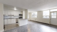This well-appointed two-bedroom, one-bathroom unit at 2292 Weston Road in Toronto offers a thoughtfully laid-out single-floor residence. The spacious living room is a standout feature, filled with natural light from large windows and finished with distinctive checkered patterned flooring that extends throughout the unit. Baseboard heating is present in the living areas and bedrooms, ensuring comfortable year-round living.

The kitchen has been tastefully renovated, showcasing crisp white shaker cabinetry, granite-style countertops, a classic subway tile backsplash, and a full suite of stainless steel appliances including a refrigerator, stove, built-in microwave, and dishwasher. Light ceramic tile flooring completes the clean, modern aesthetic of this space.

Both bedrooms are bright and well-sized, each featuring windows with exterior views and the same checkered flooring found throughout. The primary bedroom offers a comfortable footprint, while the second bedroom includes a built-in closet with sliding doors for added storage convenience.

The bathroom is finished with floor-to-ceiling white subway tile surrounding a soaking tub, paired with clean white fixtures for a crisp, updated look. Overall, this unit presents a bright, functional, and modernly refreshed living space in the Weston neighbourhood of Toronto.