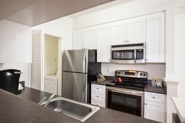 Cocina del paquete clásico I con electrodomésticos de acero inoxidable, gabinetes blancos, encimeras laminadas y pisos de superficie dura. - eaves Dublin