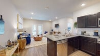 Located at 2139 New Era Rd in Sevierville, Tennessee, this single-floor home offers a thoughtfully designed open-concept layout that seamlessly connects the kitchen, dining, and living areas. The kitchen is a standout feature, showcasing dark espresso cabinetry, granite countertops, a subway tile backsplash, and a full suite of stainless steel appliances including a refrigerator, range, microwave, and dishwasher. A peninsula with bar seating provides additional prep and dining space. The adjacent living area is bright and welcoming, with recessed lighting, light wood-look flooring, and a set of French doors that open to the outdoors, filling the space with natural light. The bedroom is comfortably sized with ample natural light from a large window and continues the warm wood-look flooring found throughout the home. The bathroom is clean and functional, featuring a full soaking tub and shower combination. A dedicated laundry room with utility hookups and built-in shelving adds everyday convenience. Neutral wall tones and consistent flooring create a cohesive, modern aesthetic throughout the entire space, making this Sevierville home a comfortable and practical retreat.