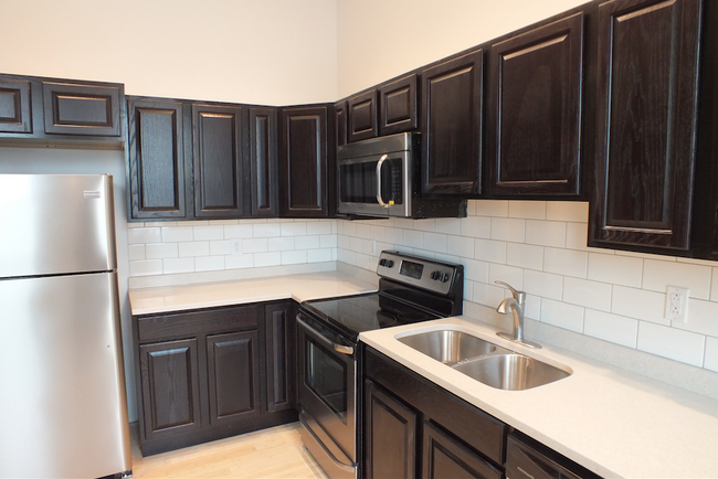 Double basin sink, granite countertops, stainless steel appliances and espresso wood cabinets - 465 E Main St