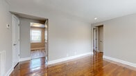 Located at 1 Marion Pepe Dr in Lodi, NJ, this single-floor residence offers a clean, well-maintained living environment with a cohesive design throughout. Rich, polished hardwood floors are a defining feature, running through the main living areas and bedrooms, adding warmth and character to the neutral-toned interiors. The walls are finished in soft gray tones, creating a bright and airy atmosphere complemented by recessed lighting and flush-mount ceiling fixtures.

The living area is spacious and open, with multiple doorways connecting to adjacent rooms, providing a smooth flow throughout the home. Bedrooms are well-proportioned, with large windows fitted with blinds that invite natural light and offer views of the surrounding greenery outdoors.

The kitchen is thoughtfully appointed with rich mahogany-toned cabinetry, white countertops, a subway tile backsplash in a soft gray-blue hue, and a full suite of stainless steel appliances including a gas range, dishwasher, and built-in microwave. Light wood-tone flooring in the kitchen provides a subtle contrast to the rest of the home.

The bathroom features classic subway tile walls accented with decorative navy and tan border tiles, gray floor tiles, a soaking tub, and a window for natural ventilation, delivering a timeless aesthetic with modern fixtures throughout.