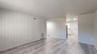 Located at 2531 Ladeara Crest Ln in Winston-Salem, NC, this 2-bedroom, 1-bathroom single-story home offers a clean, updated interior with a cohesive neutral palette throughout. The living area is a bright, open space featuring light gray wood-look flooring, distinctive vertical shiplap accent walls painted crisp white, and a textured ceiling that adds subtle character. The layout flows naturally from the living area toward the kitchen and bedrooms, making efficient use of the floor plan.

The kitchen stands out as a highlight of the home, featuring white shaker-style cabinetry, light stone-look countertops, a stainless steel sink with a gold-toned faucet, and black appliances including a range and refrigerator. A window above the sink brings in natural light, enhancing the bright, clean aesthetic.

The primary bedroom is a well-proportioned space with soft carpeting and dual closets set against a vertical shiplap wall, offering ample storage. The second bedroom also features carpet flooring and a window that allows natural light in, along with an exposed painted brick accent wall that adds texture and character.

The bathroom is neatly appointed with a shower/tub combo, a vanity with a speckled countertop, and neutral gray walls. Throughout the home, the consistent use of light tones and updated materials creates a fresh, move-in-ready atmosphere.