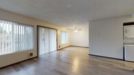 This single-floor residence offers a well-organized layout designed for comfortable everyday living. The open living and dining area is a standout feature, showcasing light-toned hardwood flooring that reflects natural light streaming in through sliding glass doors fitted with vertical blinds — providing both outdoor access and a bright, airy atmosphere. A ceiling fan adds practical comfort to this central gathering space, which flows seamlessly into an additional open area ideal for dining or flexible use.

The kitchen is efficiently designed with dark espresso-toned cabinetry providing ample upper and lower storage, a light countertop with an integrated sink, and a full suite of stainless steel appliances including a refrigerator, dishwasher, and range. Light hardwood flooring continues throughout, lending a cohesive and clean aesthetic.

The bedrooms are carpeted for warmth and comfort, each featuring neutral walls, textured ceilings, and windows that allow in natural light. Closet access is present in the bedrooms, offering practical storage solutions.

The bathroom is neatly appointed with a dark wood vanity, white countertop, mirrored medicine cabinet, and a full shower-tub combination — maintaining the consistent, understated design language found throughout the space.