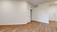 Located at 7121 Elroy Rd in Austin, TX, this well-appointed two-bedroom, two-bathroom home offers a thoughtfully designed single-level layout. Wood-look plank flooring runs throughout the main living areas, complementing the neutral, warm-toned walls that create a bright and cohesive atmosphere.

The kitchen and living room share an open-concept space, where the kitchen stands out with crisp white shaker cabinetry, granite-style countertops, stainless steel appliances including a range, over-the-range microwave, and refrigerator, plus recessed lighting overhead. Additional built-in cabinetry near the entryway provides extra storage and counter space. The living area features French doors that open onto a private balcony, allowing natural light to fill the room.

The primary bedroom offers a comfortable footprint with plush carpeting, direct access to an en-suite bathroom, and a dedicated closet. The walk-in closet is well-organized with built-in shelving, double hanging rods, and carpeted flooring. The second bedroom also features carpet and a window with natural light. Both bathrooms are finished with white subway tile surround tub/shower combos, wood-look flooring, and white cabinetry with granite-style countertops.