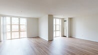 Located at 50 Park Row W in the heart of Providence, Rhode Island, this single-floor residence offers a clean, modern aesthetic throughout. The expansive open-plan living and dining area is a defining feature, characterized by warm hardwood-style flooring, crisp white walls, and an abundance of natural light pouring in through large floor-to-ceiling windows that frame urban views of the surrounding cityscape.

The kitchen is thoughtfully designed with dark espresso cabinetry, granite-style countertops, a neutral tile backsplash, and stainless steel appliances including a range and over-the-range microwave, providing both style and functionality. The layout flows seamlessly from the kitchen into the generous living area, creating a connected and versatile space.

Two full bathrooms are finished consistently, each featuring a combined tub and shower unit, light countertop vanities with ample mirror space, and hardwood-style flooring that ties the design together cohesively. The bedrooms are well-proportioned, with large windows offering city views and hardwood-style floors continuing throughout.

The overall ambiance is bright, airy, and contemporary, making it an ideal urban residence in one of Providence's most accessible downtown locations.