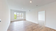 Located on Westwood Boulevard in Los Angeles, this modern single-floor unit offers a clean, contemporary design with an open and airy feel throughout. The living area features warm hardwood-style flooring, crisp white walls, and large windows that invite abundant natural light and views of the surrounding greenery. The open-concept layout connects the living space seamlessly to the kitchen, which is outfitted with stainless steel appliances including a refrigerator, range, and microwave, complemented by two-tone cabinetry, a white quartz countertop, and stylish pendant lighting overhead. One of the bedrooms includes a sliding glass door leading to a private balcony, while another bedroom features a built-in closet with shelving for ample storage. Both bathrooms are finished with large-format tile flooring, wood-toned vanities, and white quartz countertops. The primary bathroom includes a backlit mirror and direct access to a walk-in closet, while the secondary bathroom features a full shower-tub combo with white subway tile surround and matte black fixtures. Recessed lighting and a neutral palette throughout the unit contribute to a bright, modern ambiance well-suited to the vibrant Westwood neighborhood of Los Angeles.