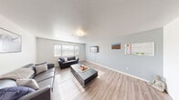 Located at 344 S 1990 E St in St. George, Utah, this well-appointed 6-bedroom, 4-bathroom unit offers a practical and comfortable layout across a single floor. The open living room is bright and inviting, featuring light wood-style flooring, a textured ceiling, and a large window that allows natural light to fill the space. The kitchen is efficiently designed with warm honey-toned cabinetry, ample counter space, a double sink, and a full-size refrigerator. A notable feature is the dedicated walk-in pantry, providing generous storage. The kitchen also accommodates a dining area for everyday meals. Each of the six bedrooms is thoughtfully outfitted with wood-style flooring, a window with blinds, a built-in desk with drawers, and a reach-in closet with shelving — ideal for individual occupants seeking both comfort and functionality. The four bathrooms are clean and straightforward, featuring wood-toned vanities, wide mirrors, and simple, durable finishes. A dedicated utility room adds further convenience to the layout. The overall aesthetic of the unit is neutral and practical, with light gray walls and consistent flooring throughout, creating a cohesive and easy-to-maintain living environment suited for shared or multi-occupant living.