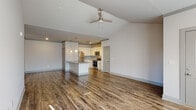 Located at 355 The Preserve Dr in Athens, GA, this single-floor residence offers a thoughtfully designed open-concept layout that seamlessly connects the living area and kitchen. Soaring vaulted ceilings throughout the main living space create an impressive sense of airiness and volume, complemented by rich wood-look flooring and abundant natural light streaming through large windows and a glass door that opens to an outdoor area.

The kitchen is a standout feature, outfitted with crisp white shaker cabinetry, granite countertops, a mosaic tile backsplash, and a full suite of stainless steel appliances including a refrigerator, microwave, and range. A peninsula with a granite countertop extends into the living area, providing additional prep space and casual seating. Pendant lighting and track lighting illuminate the kitchen with both style and function.

The bedroom offers plush carpeting, a vaulted ceiling, and a bright window that fills the room with natural light. The bathroom is finished with a granite-topped white vanity, wood-look flooring, a framed mirror, and a walk-in shower with classic white subway tile. A ceiling fan in the living area adds comfort and enhances the home's modern aesthetic.