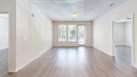 Located at 2700 E College Ave in Decatur, GA, this well-appointed 2-bedroom, 2-bathroom apartment offers a thoughtfully designed single-level layout with a clean, contemporary aesthetic throughout. The open-concept kitchen serves as the heart of the home, showcasing light gray flat-front cabinetry, a subway tile backsplash, quartz countertops, stainless steel appliances, and a center island with a built-in sink and pendant lighting above — ideal for both cooking and casual dining. Hardwood-style flooring flows seamlessly throughout the living areas and bedrooms, complementing the bright, neutral color palette. The spacious primary bedroom features a ceiling fan and access to a private en-suite bathroom, which includes a tiled soaking tub and shower combo, a generous vanity with a framed mirror, and direct entry to a walk-in closet outfitted with wire shelving systems for organized storage. The second bedroom is equally well-lit, with a large window offering outdoor views and ample natural light. A second walk-in closet provides additional storage convenience. Both bathrooms are finished with light tile flooring and clean, modern fixtures. The overall ambiance is bright, airy, and move-in ready.