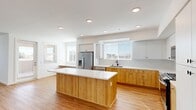 Located at 36101 Inland Valley Drive in Wildomar, CA, this thoughtfully designed single-story residence offers a clean, modern aesthetic throughout. The open-concept kitchen and living area serves as the heart of the home, featuring warm wood-tone lower cabinetry paired with crisp white upper cabinets and a large central island with a white countertop — ideal for both cooking and casual dining. Stainless steel appliances, including a French door refrigerator and dishwasher, complement the space, while recessed lighting and multiple windows with blinds flood the area with natural light. A built-in bench beneath the kitchen window adds a charming functional touch. Warm-toned hardwood-style flooring flows consistently throughout every room, creating a cohesive and inviting ambiance. The bedroom is generously sized, featuring a ceiling fan, a bright window with outdoor views, and direct access to a spacious walk-in closet equipped with multi-level shelving and hanging rods. The full bathroom continues the home's consistent design language with wood-tone cabinetry, a white countertop vanity, a large wall mirror, and a tub-shower combination. Two hallways connect the layout efficiently, and the overall design emphasizes clean lines, neutral tones, and abundant natural light.