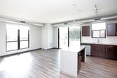 This well-appointed single-floor unit showcases a contemporary design with thoughtful finishes throughout. The open-concept kitchen is a standout feature, boasting rich dark-espresso cabinetry, light granite-style countertops, a white subway tile backsplash, and a full suite of stainless steel appliances including a refrigerator, range, and built-in microwave. A central island with pendant lighting overhead adds both function and style, while large windows invite an abundance of natural light.

The living area features wood-look plank flooring and exposed ductwork that lends an industrial-modern aesthetic, complemented by generous windows offering outdoor views of the surrounding urban landscape and greenery.

The bedrooms are carpeted for comfort and include large windows that frame views of the neighborhood. Each bedroom benefits from dedicated walk-in closet space, equipped with wire shelving systems that maximize storage capacity.

Two bathrooms serve the unit, each finished with dark vanity cabinetry, granite-style countertops, and wood-look flooring. One bathroom features a tub-shower combination, while the second offers a clean, functional layout with a windowed vanity area. The consistent use of quality materials and a neutral color palette gives the entire space a cohesive, modern feel.