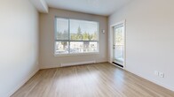 Located at 691 Hoylake Ave in Langford, BC, this well-appointed one-bedroom, one-bathroom unit offers a thoughtfully designed layout with modern finishes throughout. Light oak-toned laminate flooring flows through the open-concept kitchen and living area, creating a bright and cohesive feel. The kitchen is a standout feature, equipped with crisp white cabinetry, stone-look granite countertops, stainless steel appliances including a refrigerator, stove, microwave, and dishwasher, and a central island that doubles as a breakfast bar. Large windows in the living area frame views of the surrounding Langford neighbourhood and lush evergreen trees, while a glazed door leads directly to the private balcony, filling the space with abundant natural light. The bedroom is a comfortably sized retreat with light-toned flooring, neutral walls, and a closet. The bathroom features tile flooring, a granite-topped vanity with white cabinetry, and a full tub-shower combination. Additional highlights include in-unit laundry, a hallway with multiple closets for generous storage, and a clean, contemporary aesthetic throughout.
