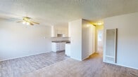 This single-floor unit in Suisun City, California offers a practical and functional layout designed for comfortable everyday living. The open-concept living and dining area is finished with wood-look vinyl plank flooring and features a ceiling fan with light fixture, a wall-mounted air conditioning unit, and a textured ceiling throughout. Natural light filters in through a large window, offering views of surrounding greenery and creating a bright, airy atmosphere.

The kitchen flows directly off the living area and is equipped with white cabinetry featuring raised-panel detailing, laminate countertops, a stainless steel refrigerator, a dishwasher, and a double-basin sink. The layout provides ample counter and storage space for everyday cooking needs.

The bedroom is generously sized with plush carpet flooring, a large window that invites natural light, and direct access to a dedicated vanity area complete with a mirrored medicine cabinet, white cabinetry, and a well-lit countertop sink. An additional door leads to a separate bathroom space. A wall-mounted HVAC unit ensures climate control throughout. The textured ceilings and neutral wall tones give the entire unit a clean, move-in ready appearance.